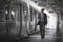 Businessman on the platform by a train carriage. — Stock Photo