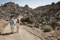 Casal caminhando através de uma paisagem rochosa — Fotografia de Stock