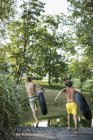 Dois meninos, saltando do molhe na água — Fotografia de Stock