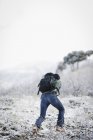 Uomo escursionismo attraverso le montagne — Foto stock