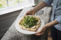 Persona che tiene un piatto con insalata fresca — Foto stock
