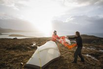 Мужчины держат и ставят небольшую палатку — стоковое фото