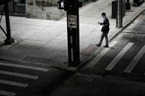 Homme marchant à travers une rue — Photo de stock