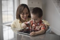 Mère et enfant avec tablette numérique — Photo de stock