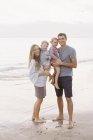 Семья на песчаном пляже у океана — стоковое фото