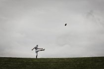 Jogador de futebol em uniforme praticando seu chute — Fotografia de Stock