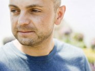 Man with stubble in a blue tee sirt — Stock Photo