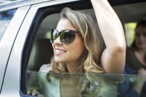 Young woman leaning out of a car — Stock Photo