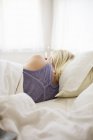 Frau schläft in einem Bett — Stockfoto