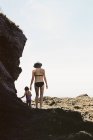 Жінка ходить з дочкою по скелях — стокове фото