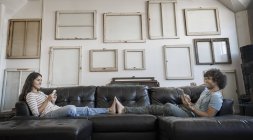 Couple assis sur le canapé — Photo de stock