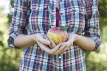 Жінка тримає велике яблуко — стокове фото