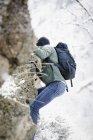 Man climbing up a rocky cliff face. — Stock Photo