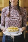 Femme portant une tarte fraîche au four — Photo de stock
