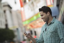 Чоловік перевіряє свій телефон на вулиці — стокове фото