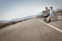 Couple on road in the desert hitchiking — Stock Photo