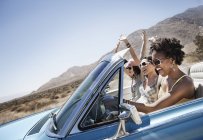 Young people in a pale blue convertible — Stock Photo