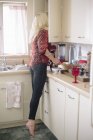 Donna in piedi in una cucina — Foto stock