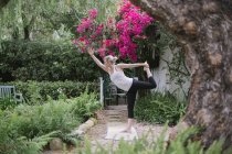 Donna che fa yoga in un giardino . — Foto stock