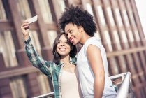 Femmes posant et prenant un selfie dans la ville — Photo de stock
