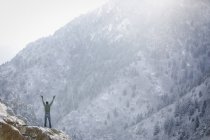 Uomo su uno sperone roccioso in montagna . — Foto stock