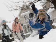 Trois enfants se battent pour une boule de neige . — Photo de stock