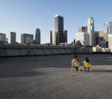 Couple on a rooftop overlooking city skyscrapers — Stock Photo