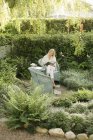 Donna seduta in un giardino, leggendo — Foto stock