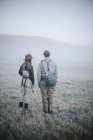 Couple walking across a meadow — Stock Photo