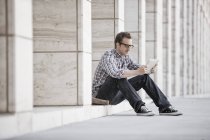 Mann entspannt sich und checkt sein Handy — Stockfoto