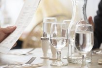 Wine and water glasses and place settings at a table — Stock Photo