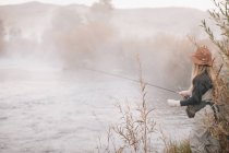 Femme sur les rives d'une rivière, pêche à la mouche . — Photo de stock