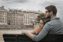 Couple sitting on a bench by the River Seine. — Stock Photo