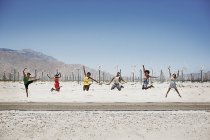 Шість молодих людей стрибають у повітрі — стокове фото