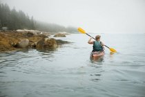 Uomo remare un kayak su acqua calma — Foto stock