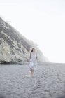 Donna che cammina su una spiaggia sabbiosa — Foto stock