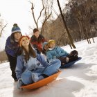 Enfants chevauchant sur des traîneaux sur la neige . — Photo de stock