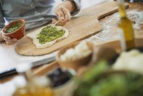 Person making a wrap and green salsa. — Stock Photo