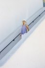 Blond woman walking down a staircase. — Stock Photo