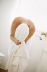 Mulher em toalha branca em um banheiro — Fotografia de Stock