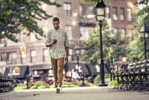 Uomo che cammina attraverso una piazza della città — Foto stock