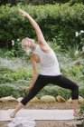 Жінка робить йогу в саду . — стокове фото