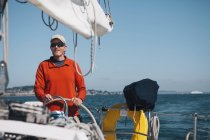 Mann mittleren Alters steuert Segelboot — Stockfoto