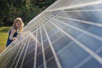 Молодая девушка рядом с солнечной батареей — стоковое фото