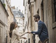 Paar hält Händchen auf einer Straße in der Stadt. — Stockfoto