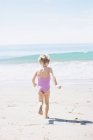 Молода дівчина в рожевому купальнику біжить — стокове фото