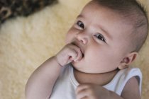 Baby girl with her hand in her mouth — Stock Photo