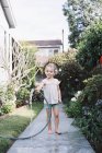 Menina de pé em um caminho em um jardim — Fotografia de Stock
