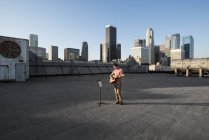 Uomo che suona una chitarra su un tetto — Foto stock