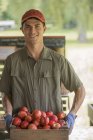 Homem segurando cestos de frutas frescas — Fotografia de Stock